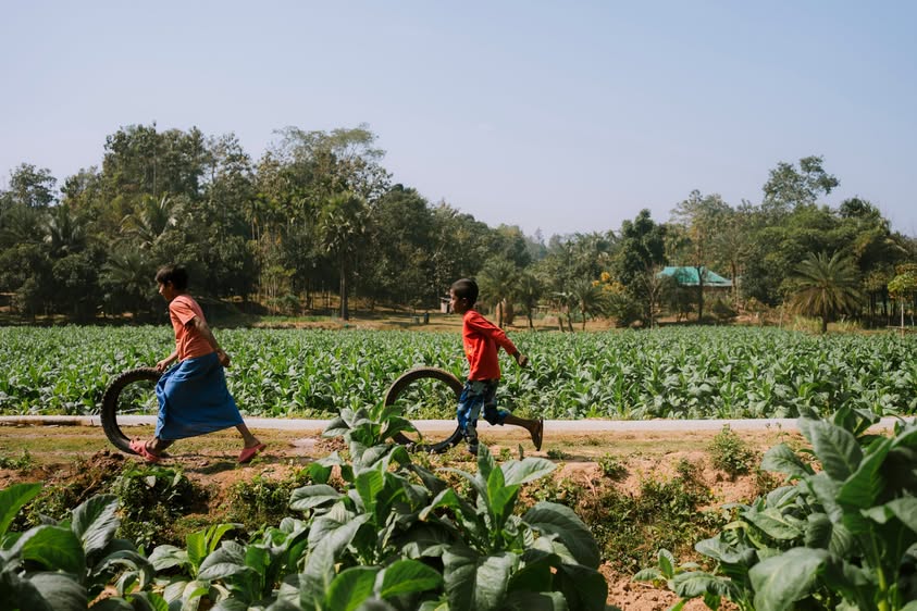Children playing with tires along a rural village path